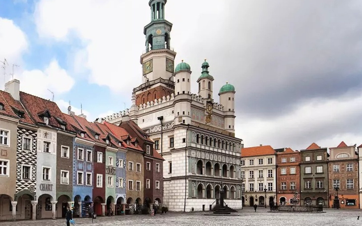 Widok na rynek z ratuszem w Poznaniu, z kolorowymi kamienicami.