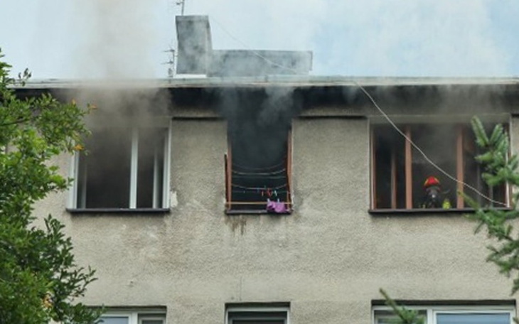 Pożar w budynku, strażak przy oknie.