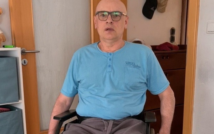 Mężczyzna na wózku inwalidzkim, siedzący w pokoju.