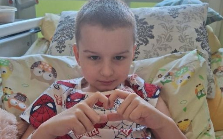 Chłopiec w szpitalu, robiący serce z rąk.