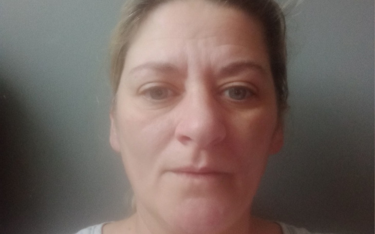 Portret kobiety z neutralnym wyrazem twarzy.