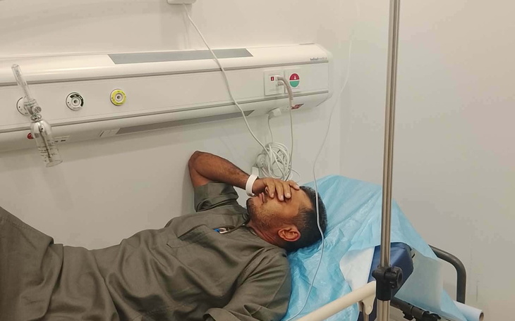 Mężczyzna leżący w szpitalu, trzymający się za twarz.