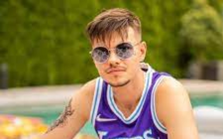 Młody mężczyzna w okularach przeciwsłonecznych przy basenie.