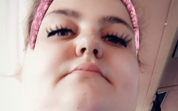 Portret osoby z różowym opaską na głowie.