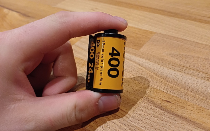 Rolka filmu fotograficznego trzymana w dłoni.