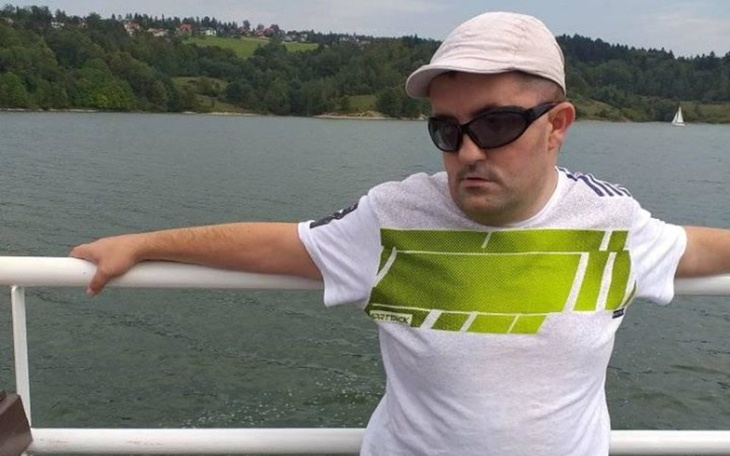 Mężczyzna w okularach przeciwsłonecznych na tle jeziora.