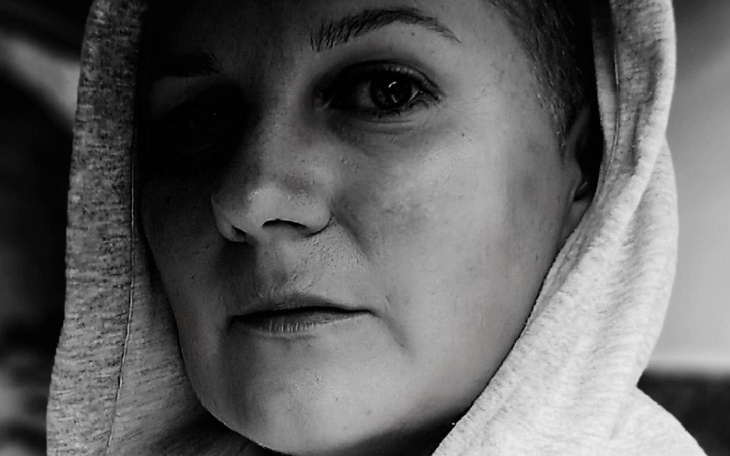 Czarnobiałe zdjęcie kobiety w kapturze.