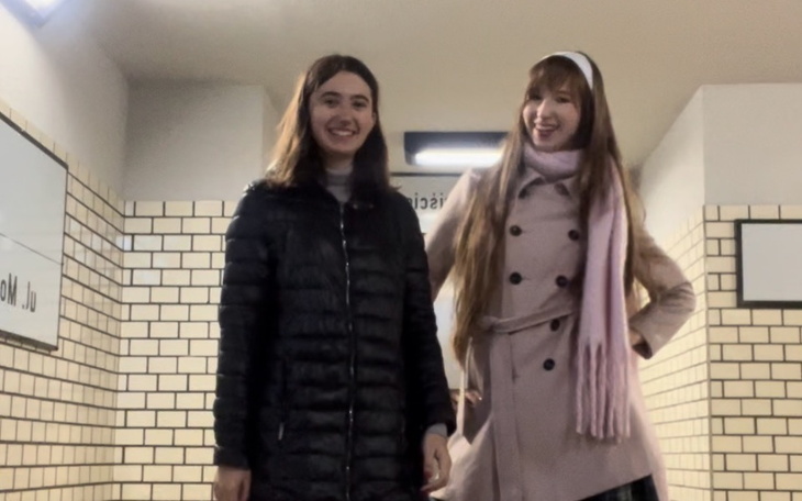 Dwie uśmiechnięte dziewczyny w przejściu, pozujące do zdjęcia.