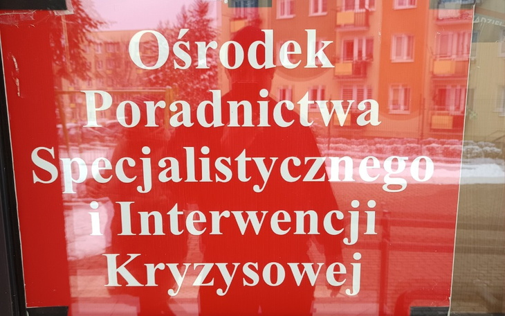 Tablica informacyjna o ośrodku poradnictwa kryzysowego.