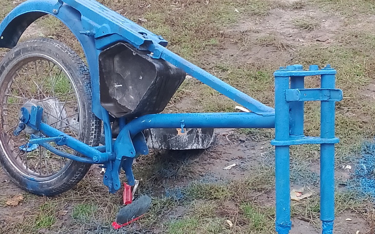 Zardzewiały rower z niekompletną ramą, stojący na trawie.