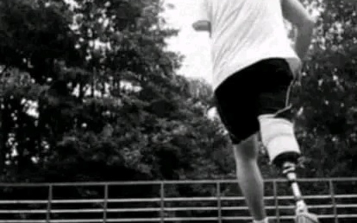 Osoba biegająca na boisku z protezą nogi.