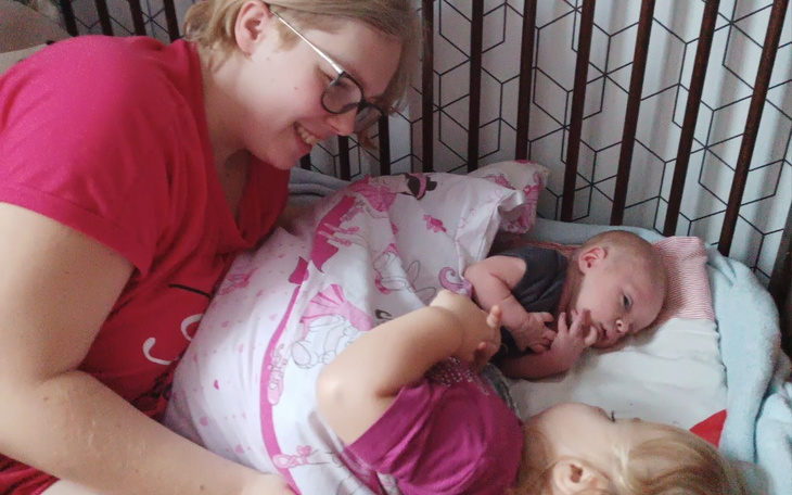 Dzieci bawiące się z uśmiechniętą opiekunką.