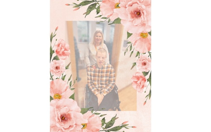 Dwie osoby na zdjęciu, jedna w wózku inwalidzkim, otoczone kwiatami.