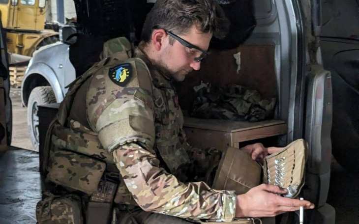 Żołnierz w mundurze, przygotowujący sprzęt w pojeździe.