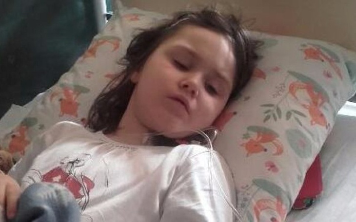 Chora dziewczynka leżąca na łóżku.