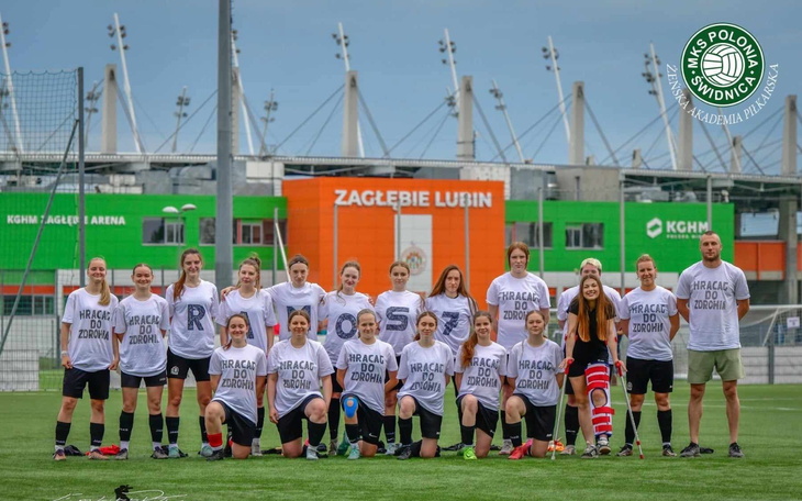 Drużyna piłkarska w koszulkach na boisku.