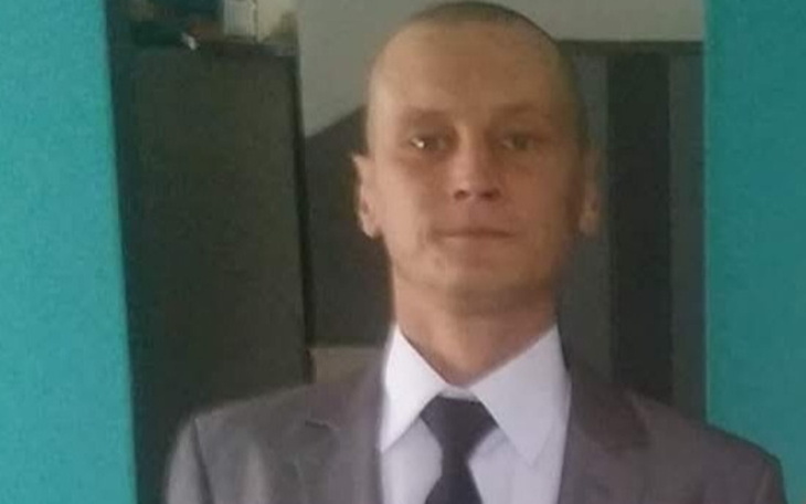 Mężczyzna w garniturze, stoi w pomieszczeniu.