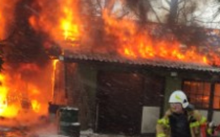 Pożar w budynku, strażak w akcji, ogień w tle.