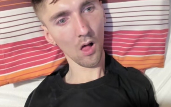 Mężczyzna leży na łóżku, wygląda na zmartwionego.