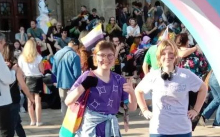 Młode osoby na paradzie, ubrane w kolorowe koszulki.