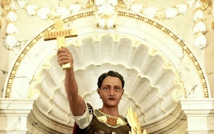 Figura świętego z krzyżem, symbolizująca wiarę i nadzieję.