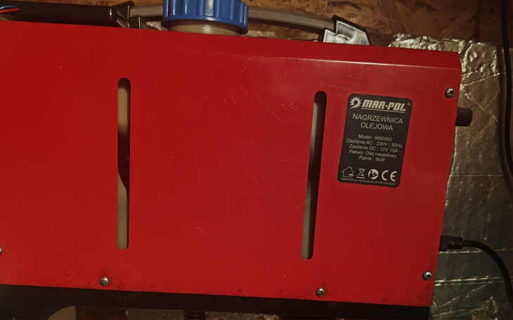 Czerwony piec olejowy w pomieszczeniu.