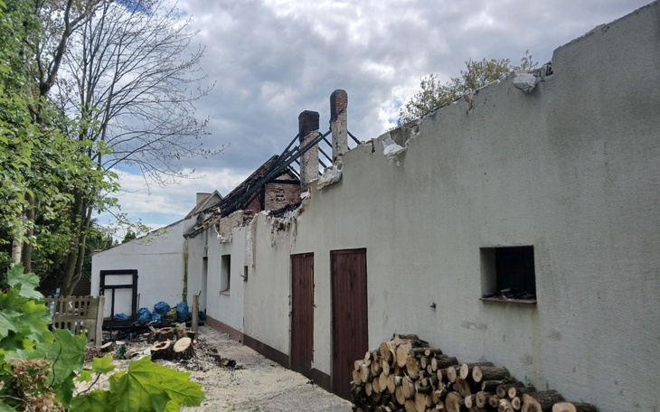 Zniszczony budynek po pożarze, z widocznymi uszkodzeniami.