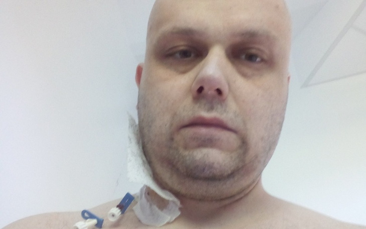 Mężczyzna w szpitalu, z widocznymi oznakami leczenia.