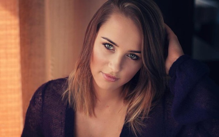 Portret kobiety z długimi włosami, uśmiechającej się.