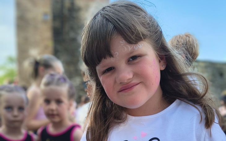 Uśmiechnięta dziewczynka z malowaniem na twarzy.