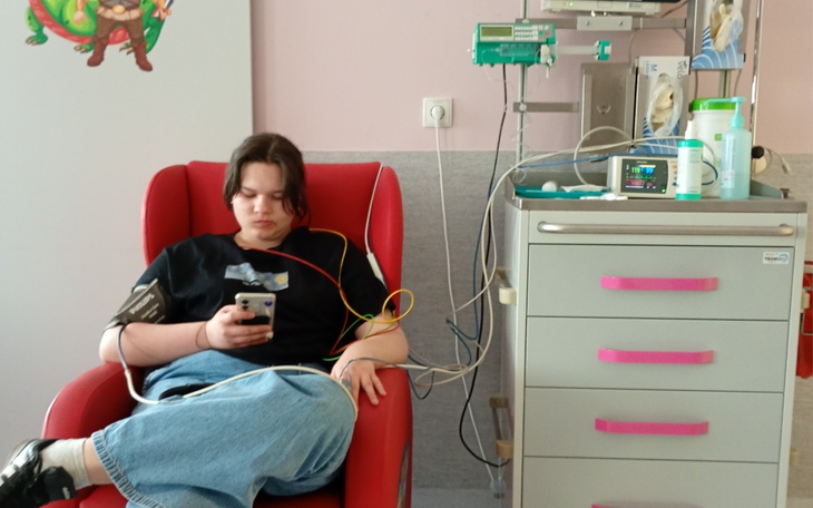 Młoda osoba w szpitalu korzystająca z telefonu.