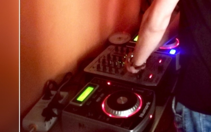 DJ miksujący utwory na sprzęcie muzycznym.