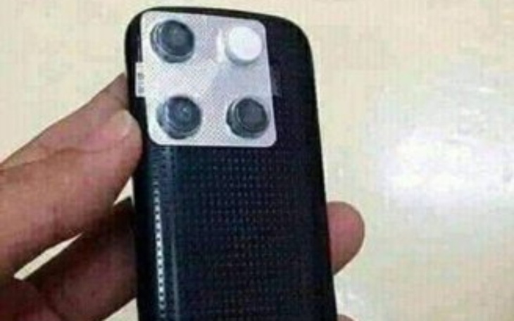 Osoba trzymająca telefon z nietypowym aparatem fotograficznym.