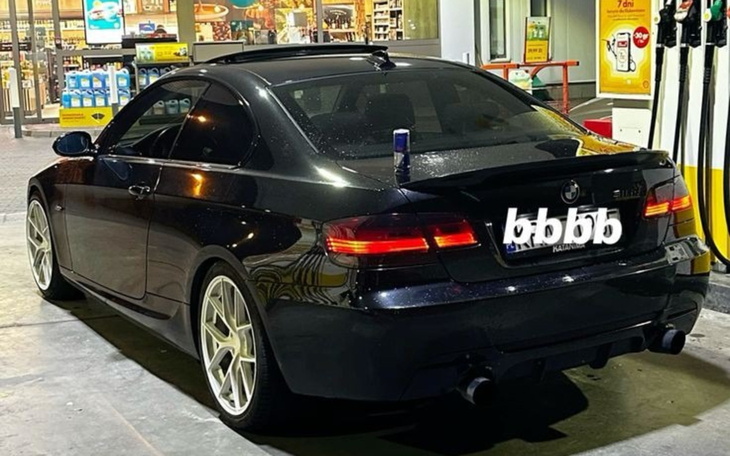 Czarny samochód zaparkowany na stacji benzynowej.