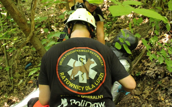 Ratownicy w akcji, pomagają poszkodowanemu w lesie.