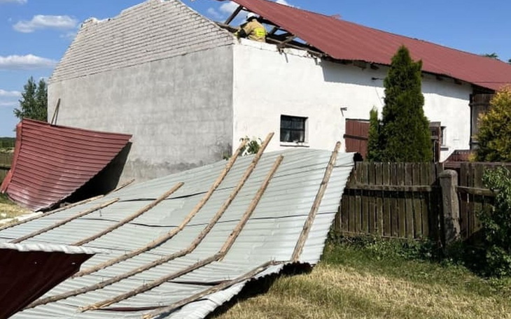 Zniszczony dach budynku po burzy, z uszkodzoną elewacją.