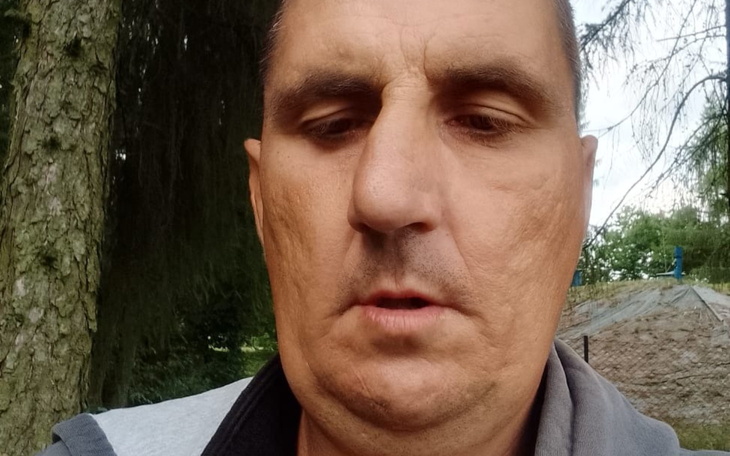 Mężczyzna w bliskim ujęciu, z poważnym wyrazem twarzy.