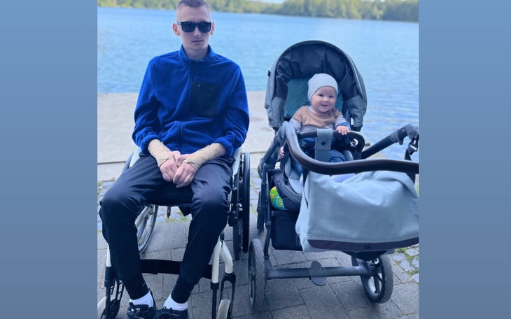 Mężczyzna na wózku inwalidzkim z dzieckiem w wózku.