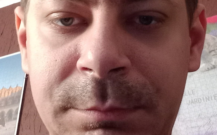 Zbliżenie na mężczyznę z poważnym wyrazem twarzy.