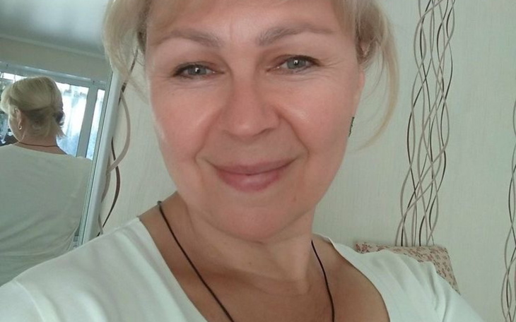 Portret uśmiechniętej kobiety w jasnym otoczeniu.