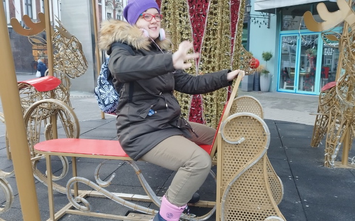 Dziewczyna bawi się na placu zabaw w zimowej scenerii.