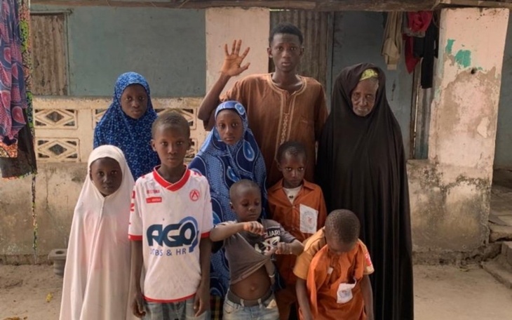 Grupa dzieci i dorosłych pozujących razem w tradycyjnych strojach.