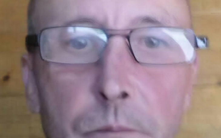 Rozmyte zdjęcie mężczyzny w okularach, z bliskiej odległości.