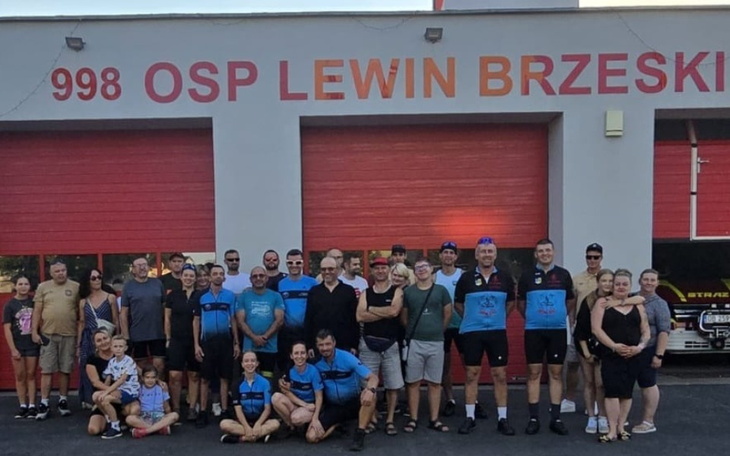 Grupa ludzi przed remizą OSP Lewin Brzeski, wspólne zdjęcie.
