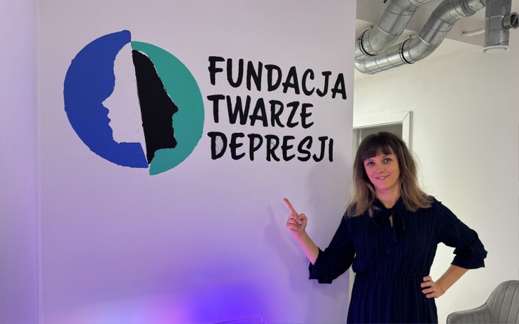 Kobieta wskazująca na logo fundacji w biurze.