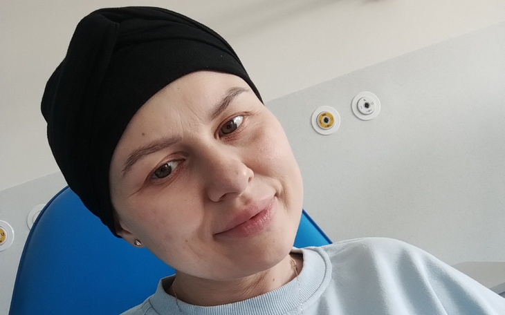 Kobieta w turbanie, uśmiechająca się w szpitalnym otoczeniu.