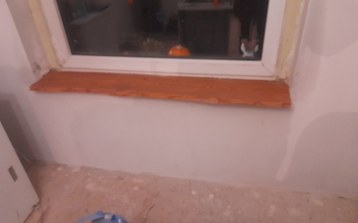 Nowo wykonany parapet drewniany przy oknie w trakcie remontu.