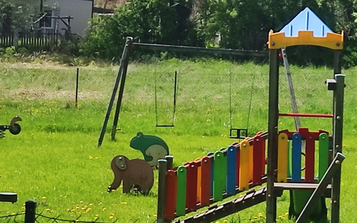 Plac zabaw z huśtawkami i kolorowymi figurkami.