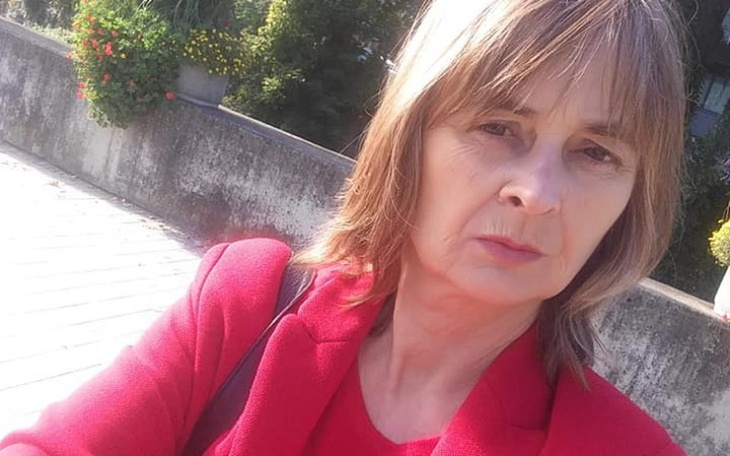 Kobieta w czerwonym ubraniu, selfie na tle zieleni.