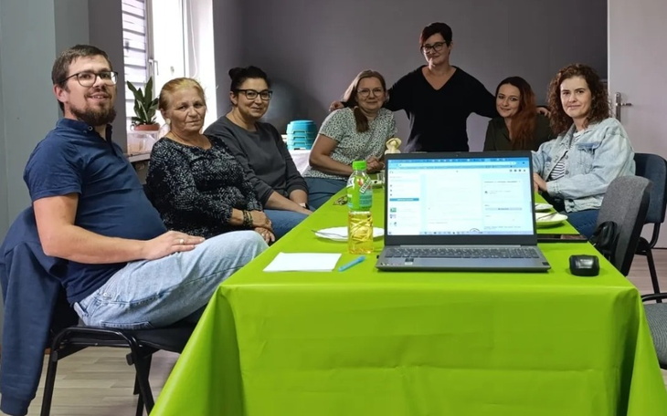 Grupa ludzi przy stole, pracują nad wspólnym projektem.